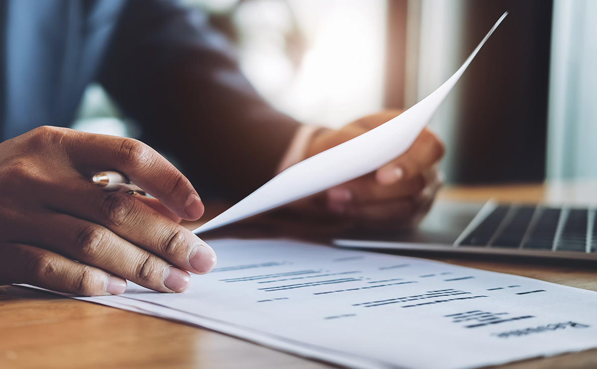 Closeup of a person reading paperwork within a professional environment